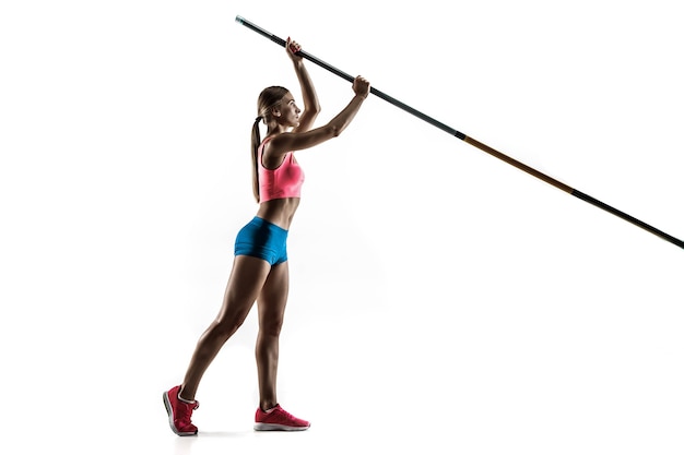 Power and beauty and purity. Professional female pole vaulter training on white wall. Fit and slim female model practicing. Concept of sport,