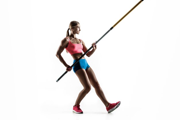 Power and beauty and purity. Professional female pole vaulter training on white wall. Fit and slim female model practicing. Concept of sport,