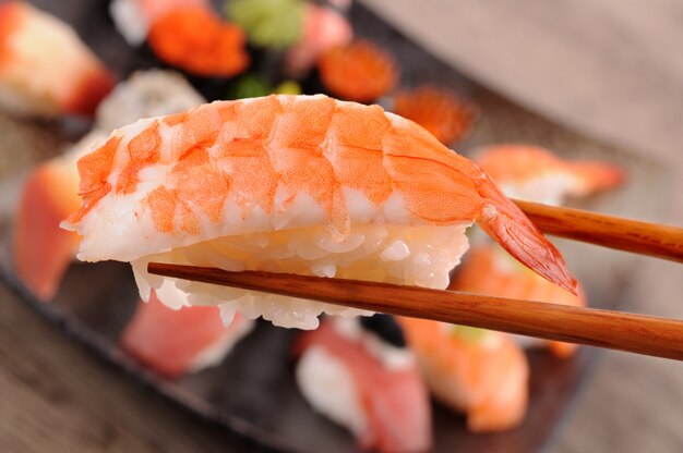 Prawn sushi held by chopsticks