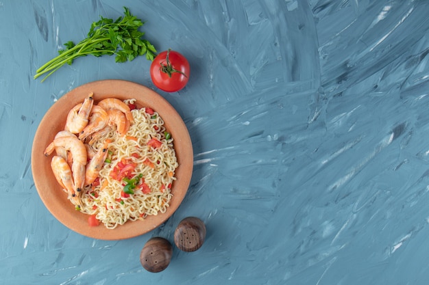 Gamberi e vermicelli in una ciotola, sullo sfondo di marmo.