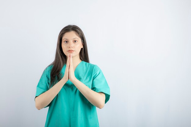 Молящаяся молодая красивая медсестра