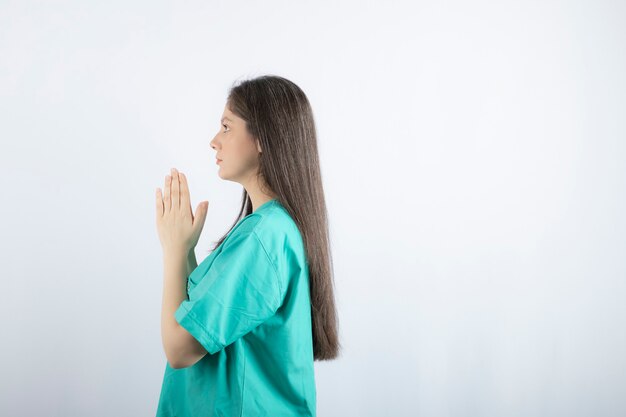 Praying young nurse woman