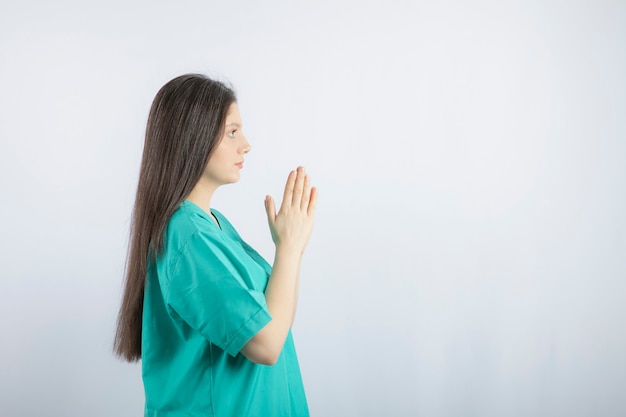 Praying young nurse woman