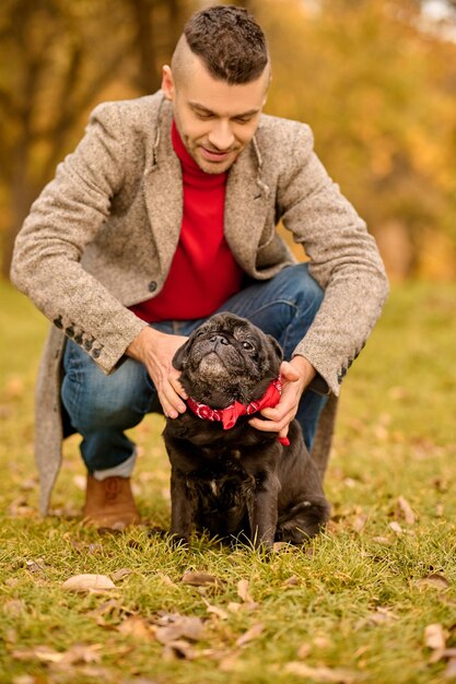 Preapring for the walk. A pet owner putting on the dog-collar on his dog