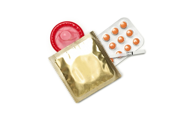 Pregnancy test, condoms and pills isolated on white surface