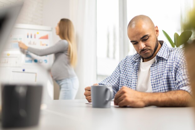 Pregnant businesswoman giving a presentation while male coworker listens