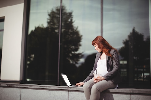 Pregnant businesswoman using laptop