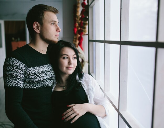 Pregnant couple looking out of window