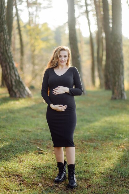 숲에서 야외 산책 임신 행복 한 젊은 여자