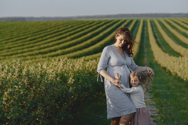 Pregnant mother with her daughter in a field