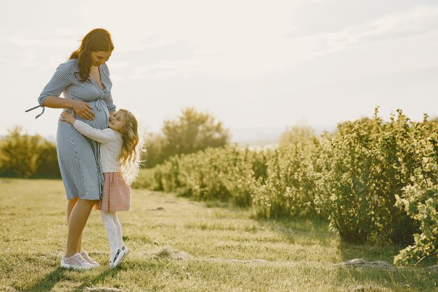 Pregnant mother with her daughter in a field