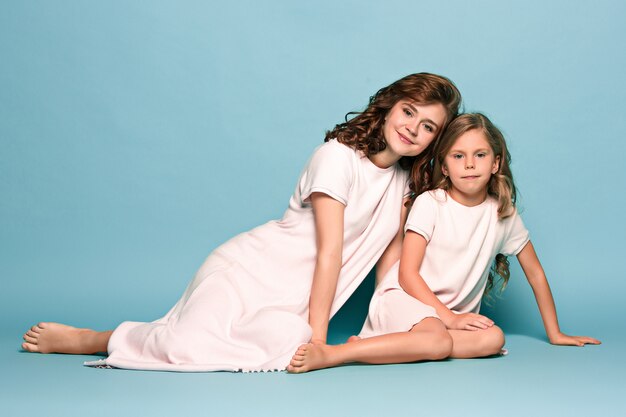 Pregnant mother with teen daughter. Family studio portrait 