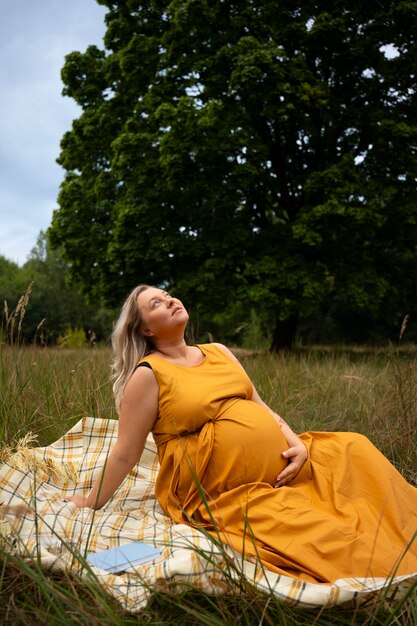 임신 중인 플러스 사이즈 여성이 휴식을 취하고 있습니다.