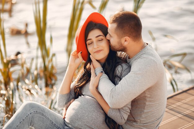 Pregnant wife with her husband standing near river