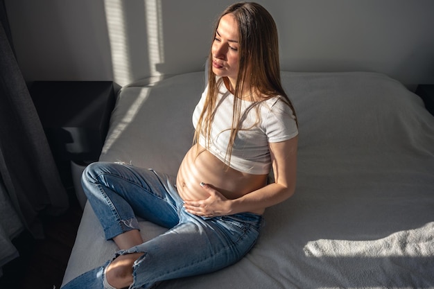 Free photo pregnant woman on the bed in the room on a sunny morning