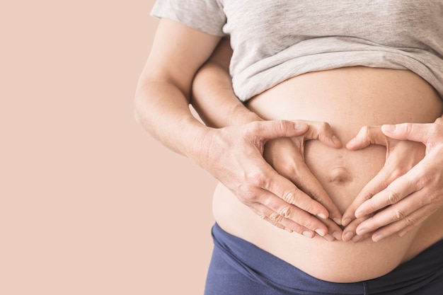 Pregnant woman on a beige background