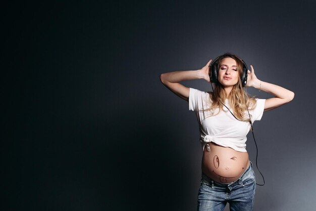 Pregnant woman dancing and smiling with closed eyes