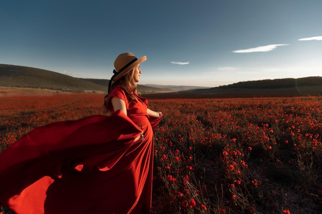 Foto gratuita donna incinta in abito nel campo di papaveri