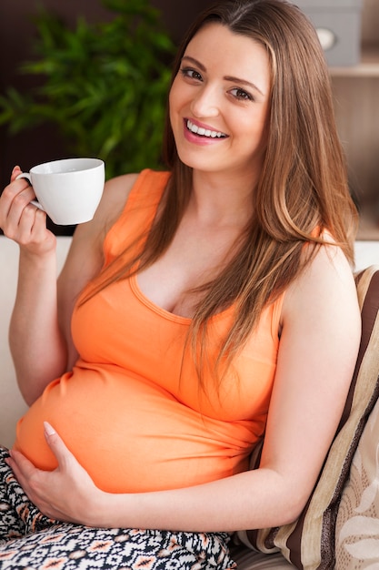 Беременная женщина пьет чай дома