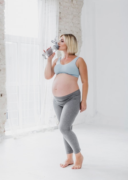 Free photo pregnant woman drinking water