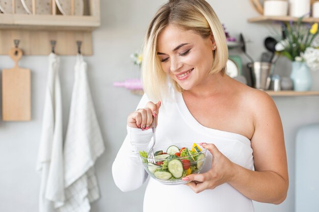 いくつかのサラダを食べる妊娠中の女性