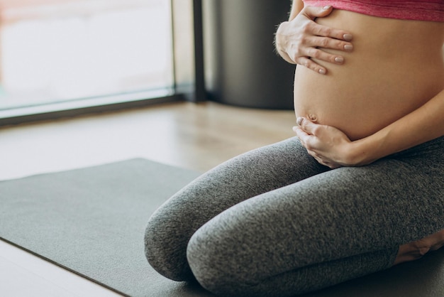 Pregnant woman exercicising on a class of pilates