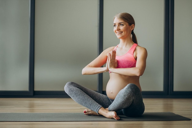 Pregnant woman exercicising on a class of pilates