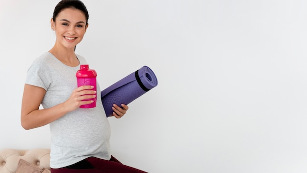 Foto gratuita donna incinta che si prepara ad esercitare con lo spazio della copia