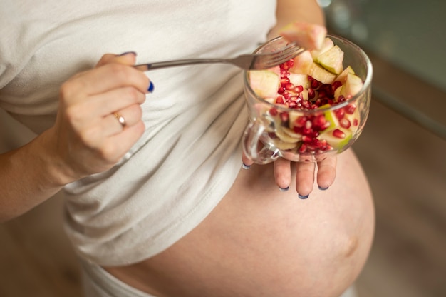 Pregnant woman hands holding a tasty salad