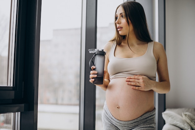 Pregnant woman having rest after exercising at home