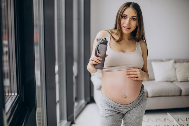 Pregnant woman having rest after exercising at home