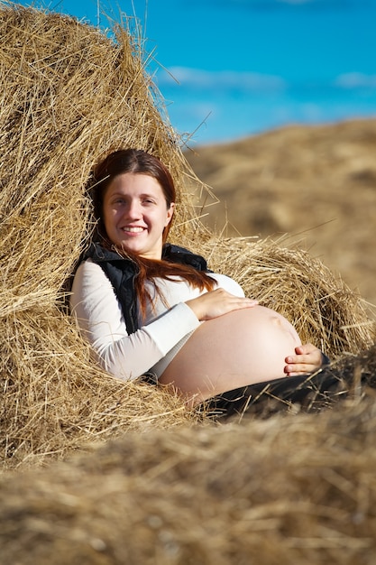 Free photo pregnant woman on hay