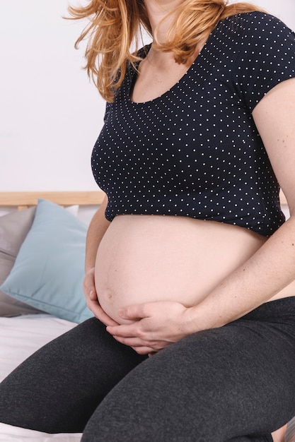 Free photo pregnant woman holding belly