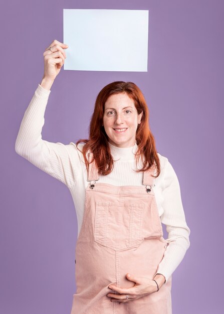 Pregnant woman holding blank paper sheet