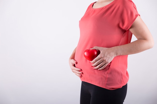 Pregnant woman holding heart