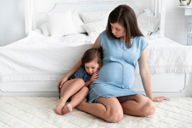 Pregnant woman holding her daughter close