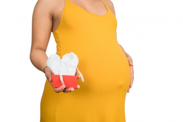 Free photo pregnant woman holding and opening gift box