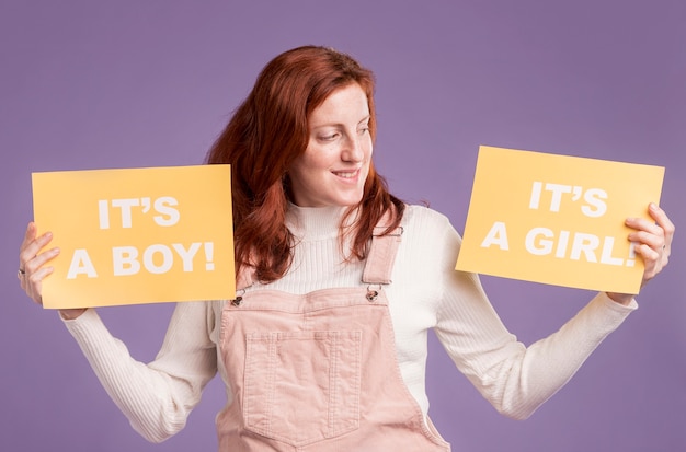 Foto gratuita carta della tenuta della donna incinta con il genere del bambino