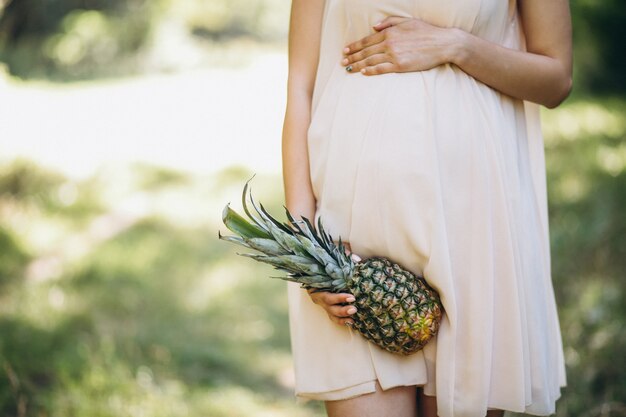 Pregnant woman holding pineapple