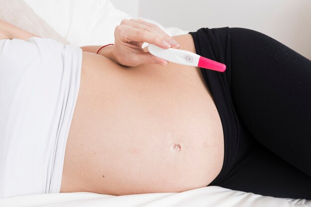 Pregnant woman holding pregnancy test