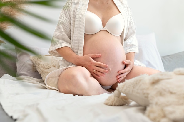 Pregnant woman holding tummy close up