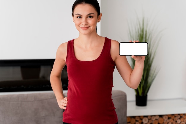 Free photo pregnant woman holding a white card in her hand