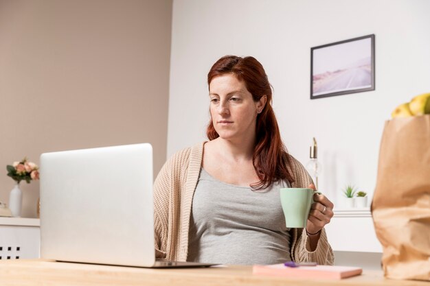 妊娠中の女性が自宅でお茶を飲む