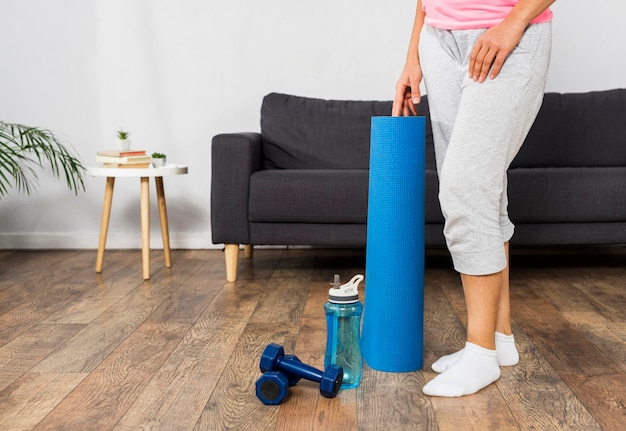 Pregnant woman at home with water bottle and weights
