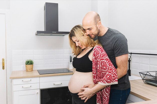 Pregnant woman and husband in kitchen