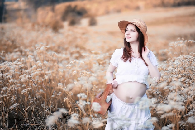 Беременная женщина на природе на прогулке осенью