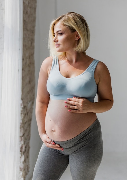 Pregnant woman looking through the window