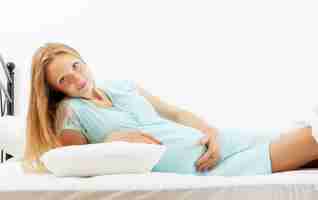 Free photo pregnant woman lying   in bed at home