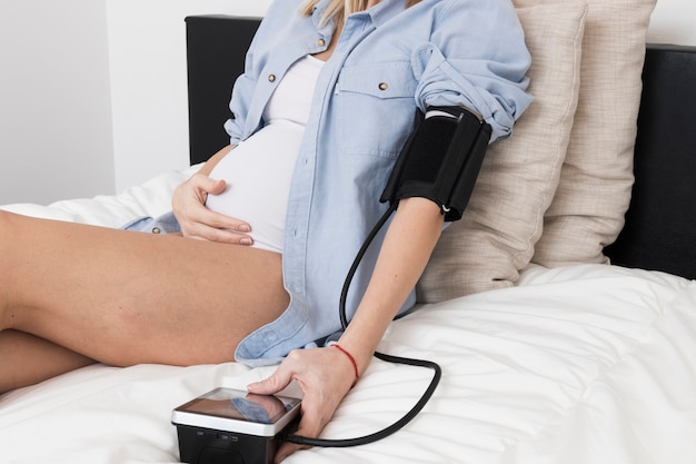 Pregnant woman measuring blood pressure