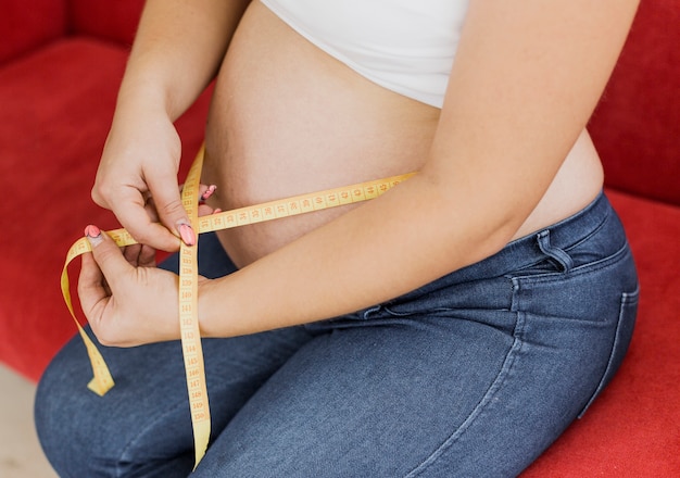 임신 한 여자는 그녀의 배꼽을 측정